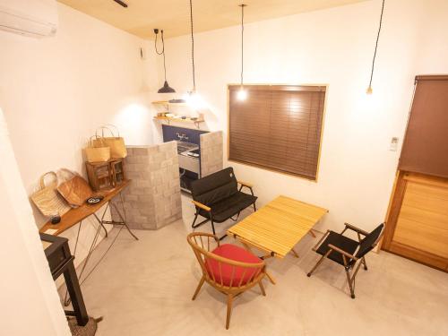 高知市にあるLifeStyleHotel ichi一棟貸切りホテルのテーブルと椅子、キッチンが備わる客室です。
