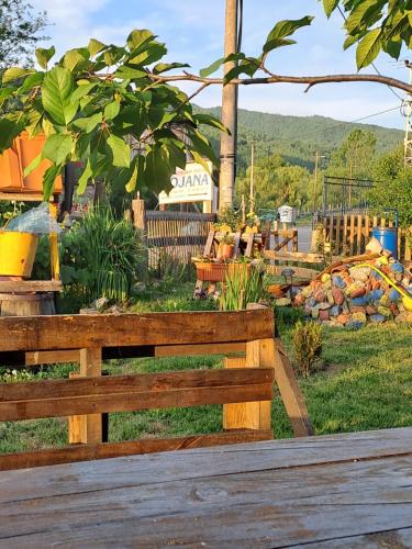 a wooden bench in front of a garden at VILA BOJANA in Inovo