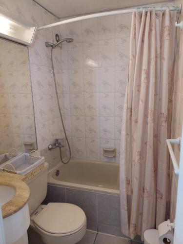 a bathroom with a toilet and a shower curtain at Sunset View in Viña del Mar