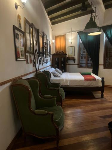 a bedroom with two beds and green chairs at 103 - Bed and Brews in Bangkok