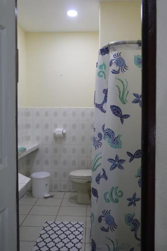 baño con cortina de ducha con peces. en Apartamento San Carlos, en Sonzacate