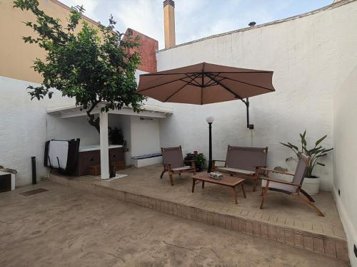 卡波泰拉的住宿－S'Incontru Affittacamere，庭院配有桌子、遮阳伞和椅子