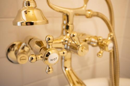 un robinet de douche en or éclairé dans l'établissement LifeStyleHotel ichi / Vacation STAY 81824, à Kōchi