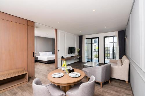 a living room with a table and chairs at One Patio Hotel Pattaya - SHA Extra Plus in Pattaya Central