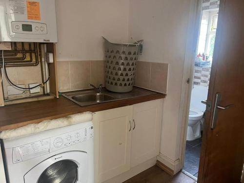 a kitchen with a washing machine and a sink at Highfield Road Apartment. in Rowley Regis