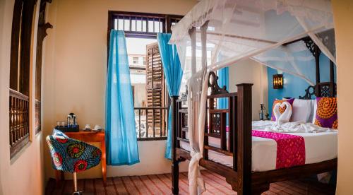 Emerald Palm في مدينة زنجبار: غرفة نوم مع سرير مظلة ونافذة