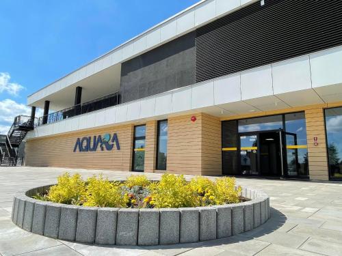 a building with a flower bed in front of it at AQUARA Radomsko in Radomsko