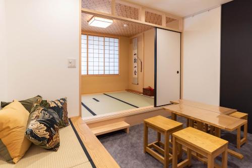 a room with a table and chairs and a room with a mirror at vacation rental SARAKU 茶楽来 in Osaka