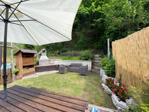 a patio with an umbrella in a yard at Casa Monica Ledro Attico in Mezzolago
