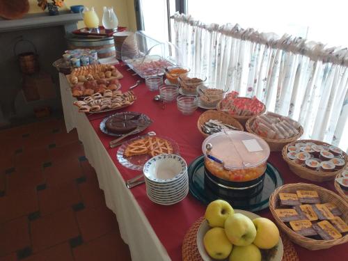 a buffet of food on a red table at Albergo Casa Al Sole in Greve in Chianti