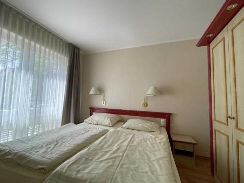 sypialnia z łóżkiem i dużym oknem w obiekcie Haus Niedersachsen Apartment 7 w mieście Timmendorfer Strand