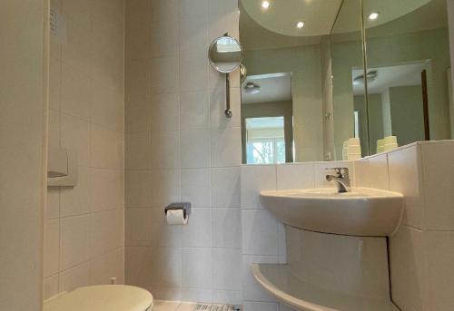 y baño con lavabo, aseo y espejo. en Haus Niedersachsen Apartment 11, en Timmendorfer Strand