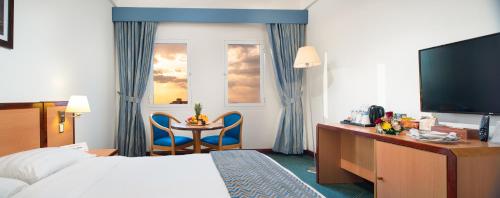 Un pat sau paturi într-o cameră la Sur Plaza Hotel