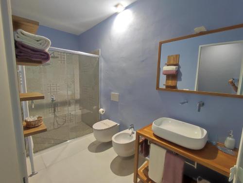 a bathroom with two toilets and a sink and a shower at Corte Piri in Tricase