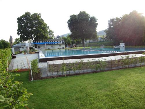 a large swimming pool in a park with a yard at Pension-Gästehaus Waldhof in Winterberg