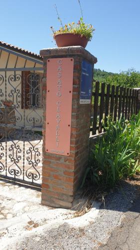 Znak na ceglanym filarze obok płotu w obiekcie Casato Clavelli 1 w mieście Collestatte