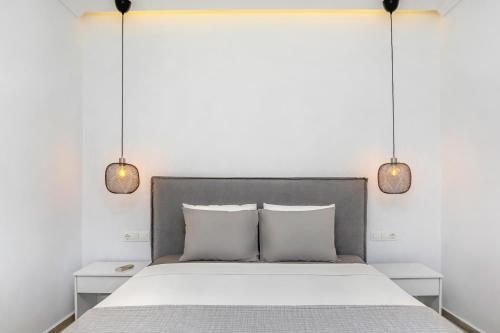 a bedroom with a bed with two lights above it at Boutique Maisonette in Pefkohori