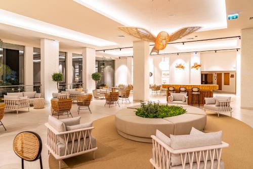 - un hall d'un hôtel avec des chaises et des tables dans l'établissement 3HB Guarana - All Inclusive, à Albufeira