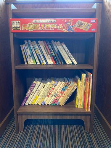 a wooden book shelf filled with lots of books at Youan in Fujikawaguchiko