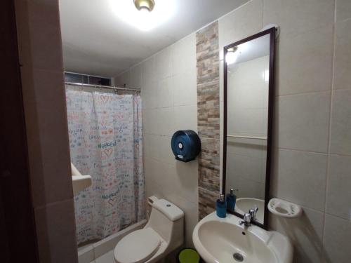a bathroom with a sink and a toilet and a mirror at Casa Villa Descanso in Lima