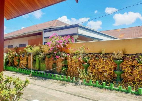 a fence with lots of flowers and plants at Hotel Mario Pulana Bone in Watampone