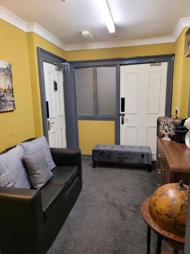 a living room with a black couch and a door at The Residence - NO 8 in Edinburgh