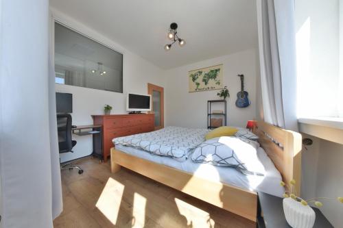 1 dormitorio con cama y escritorio en Veľký 2i byt 75m2 pri Opere v priamom centre Banskej Bystrice, AC klíma, balkón, en Banská Bystrica