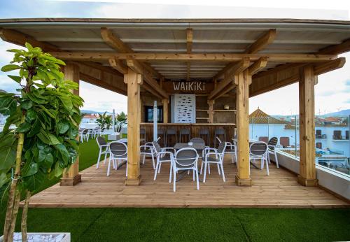 a wooden deck with chairs and a bar at Hotel Pozo del Duque in Zahara de los Atunes