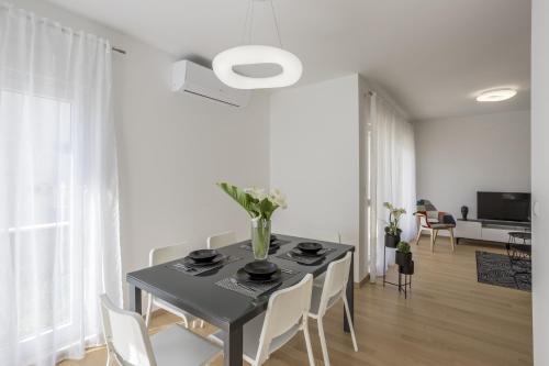 a dining room with a black table and white chairs at coaSTal apartment 1 in Split