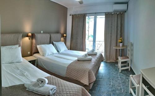 a hotel room with two beds and a window at Blue Star 2 in Pyrgi Thermis