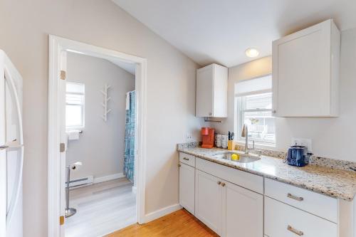 a kitchen with white cabinets and a sink at Fun and Sun in Hampton