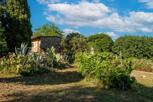 a garden with bushes and trees and a building at Stella Sud Podere Carbone in Grosseto