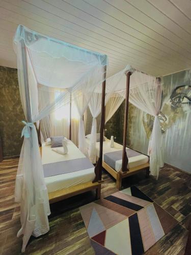 a bedroom with two beds with mosquito nets at Ifaty Beach Club Resort in Ifaty