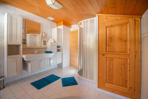 baño con ducha y puerta de madera en Appartment Lechner, en Neukirchen am Großvenediger