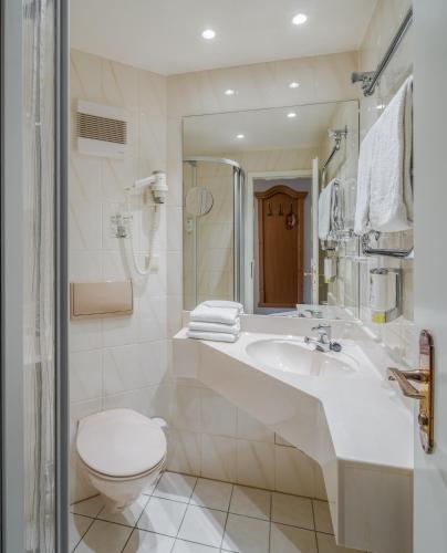 a white bathroom with a toilet and a sink at Landhotel Altes Zollhaus in Hermsdorf