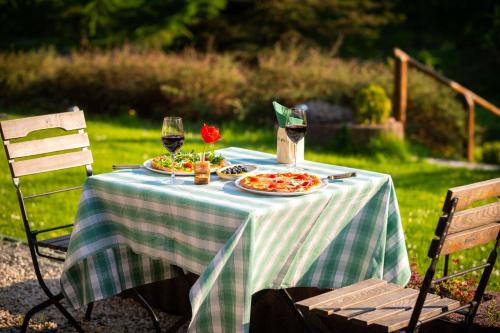 a table with two plates of food and two glasses of wine at Landhotel Altes Zollhaus in Hermsdorf