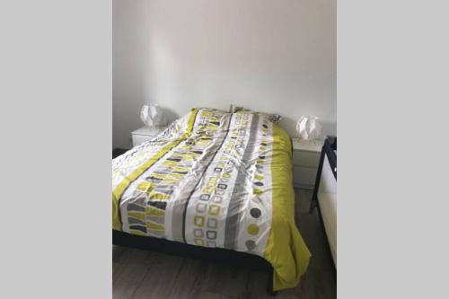 - une chambre avec un lit et une couette jaune et blanche dans l'établissement Chez mémé, à Brusvily