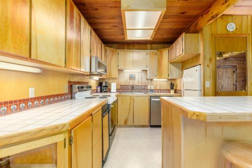 a large kitchen with wooden cabinets and white appliances at Alpine Meadows Log Cabin in Girdwood