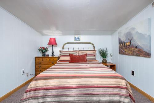a bedroom with a large bed with a striped bedspread at Alpine Meadows Log Cabin in Girdwood