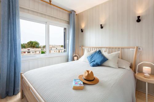 ein Schlafzimmer mit einem Bett, auf dem ein Hut liegt in der Unterkunft La Ola Beach House in Portocolom
