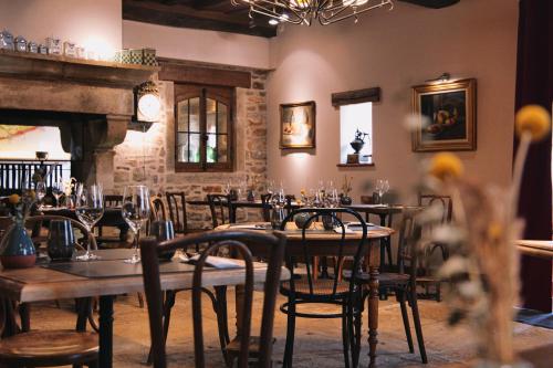 a dining room with tables and chairs and a fireplace at Hostellerie De Levernois in Levernois