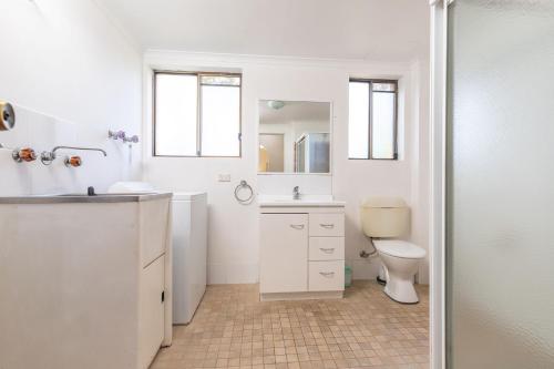 a white bathroom with a sink and a toilet at Seahorse 4 in Tuncurry