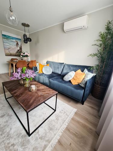 a living room with a blue couch and a coffee table at Hubane Olevi Apartment in Võru