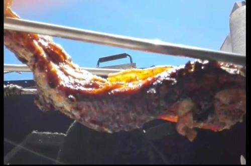 a person is holding a piece of meat with tongs at Casa Flor in Arcas