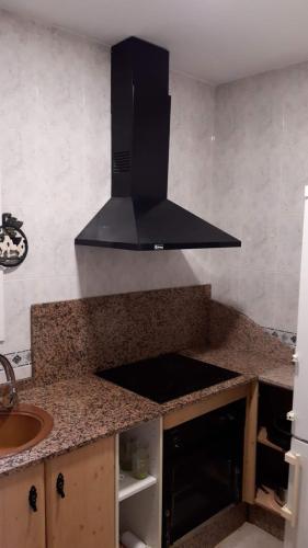 a kitchen with a black hood over a counter at Casa Flor in Arcas