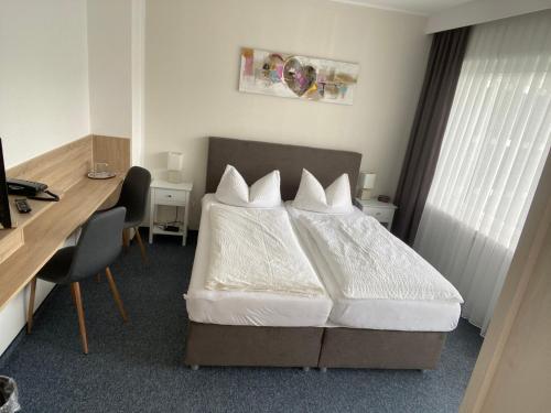 a hotel room with a bed and a desk and a computer at Sevda's Hotel Garni Weinforth in Willingen