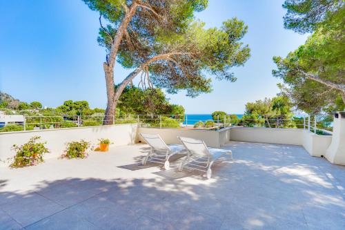 un patio con 2 sillas y vistas al océano en Ses Alzines Apartment - Costa De Los Pinos en Costa des Pins