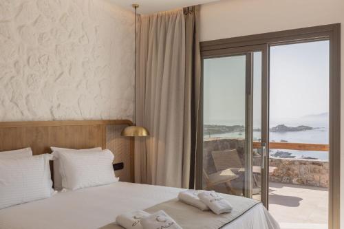 a hotel room with a bed with towels on it at Calma Suites Mykonos in Psarou
