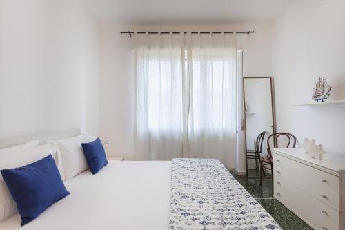 Schlafzimmer mit einem Bett mit blauen Kissen und einem Schreibtisch in der Unterkunft Santa Margherita Apartment in the city center in Santa Margherita Ligure