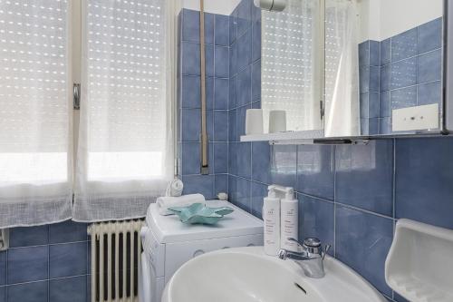 ein blau gefliestes Bad mit WC und Waschbecken in der Unterkunft Santa Margherita Apartment in the city center in Santa Margherita Ligure